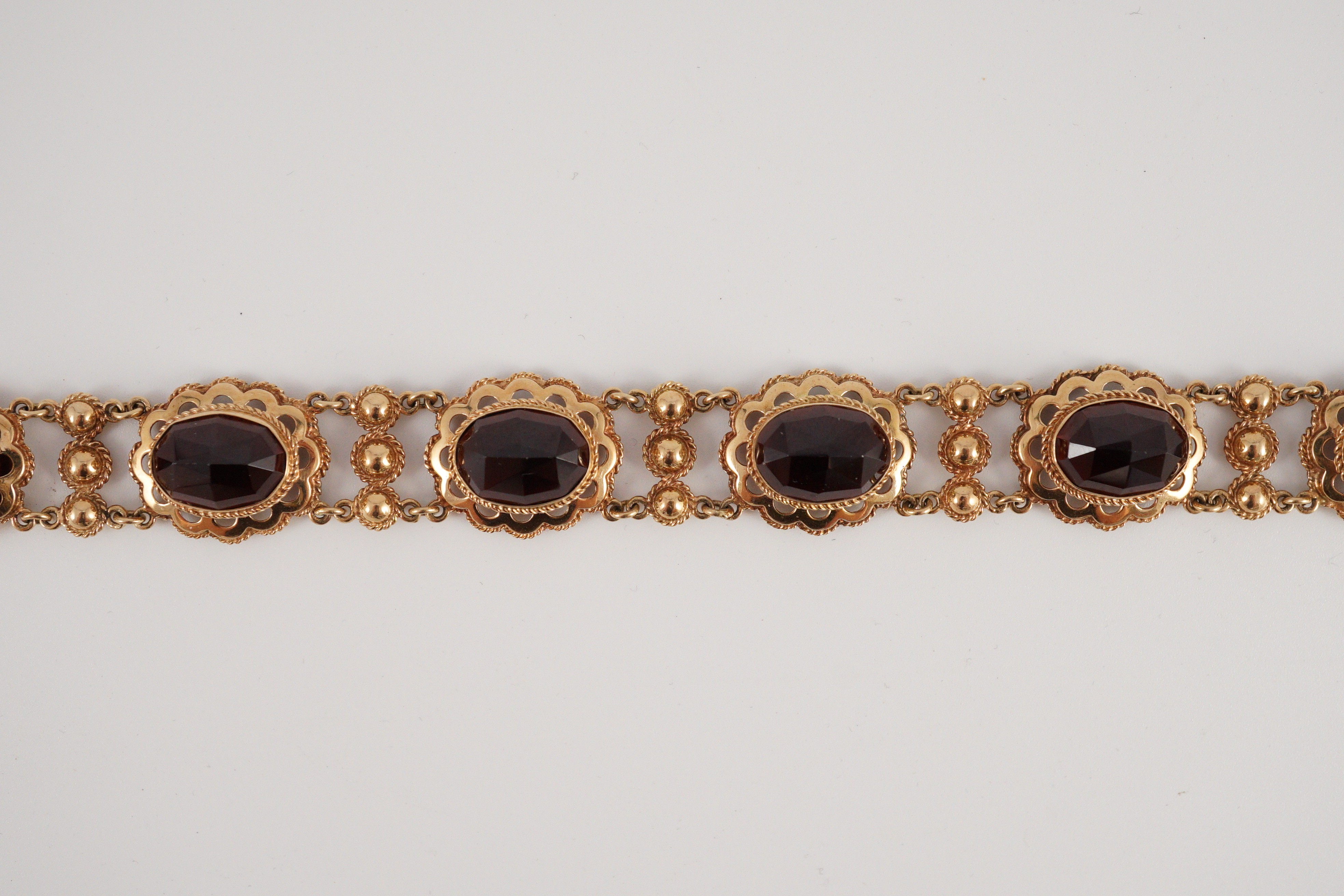 A 20th century Dutch 14k gold and six stone facet cut cabochon garnet set fancy link bracelet
